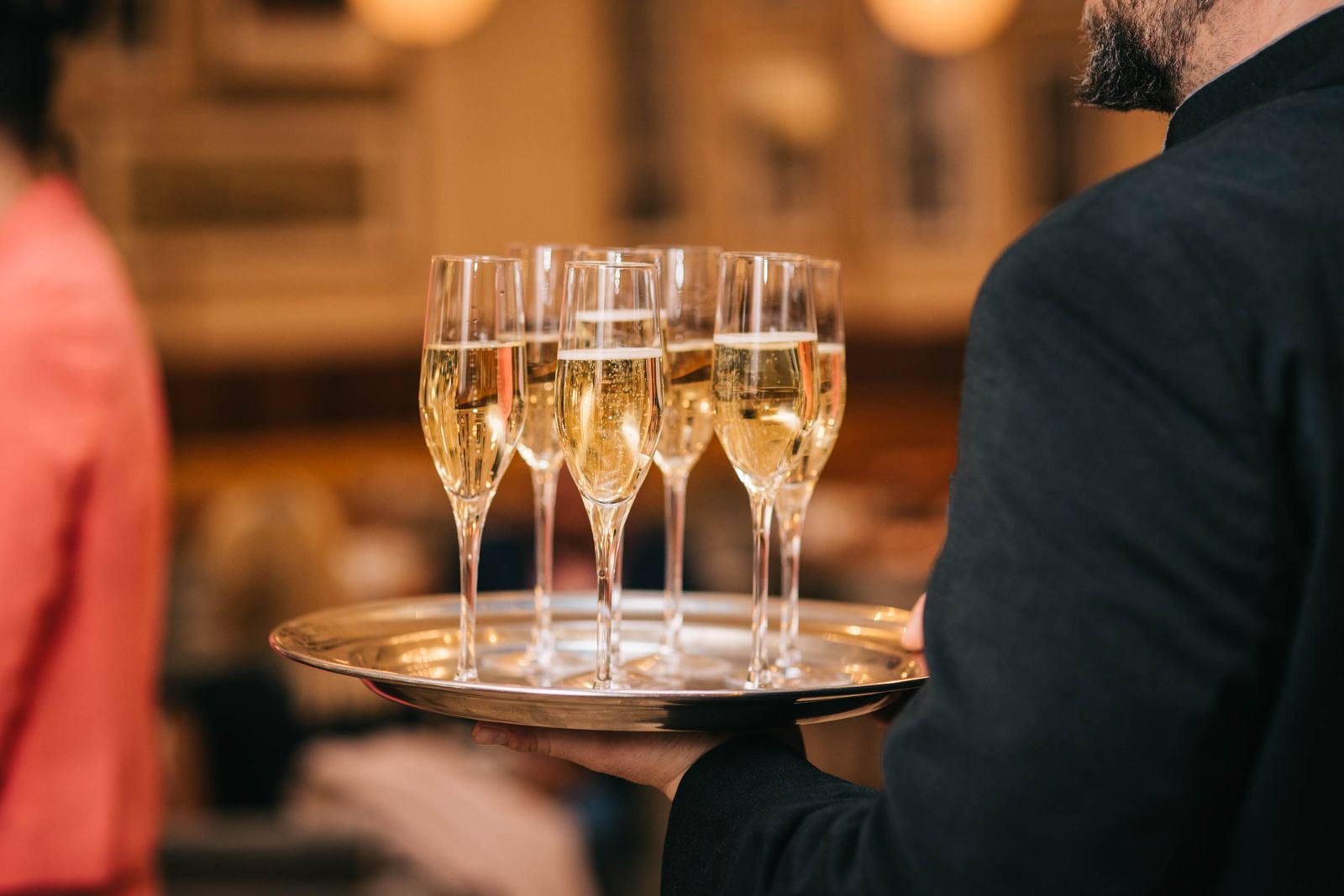 Un serveur présentant un plateau de coupes de champagne lors d'une réception